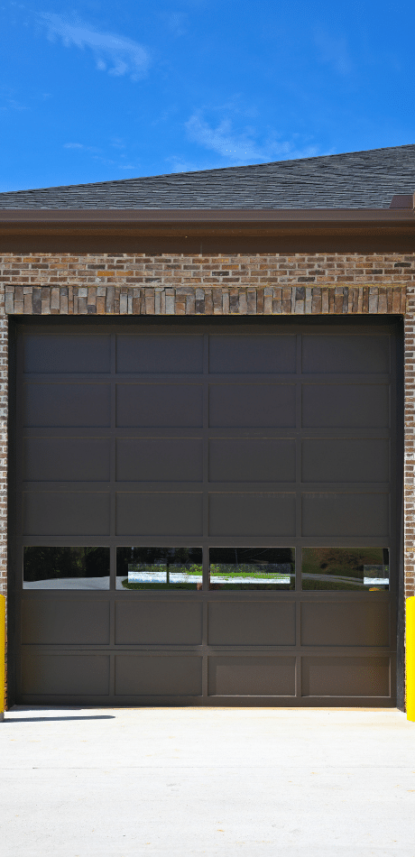 Brown panel lift garage door under a blue sky