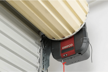 Close-up of a Grifco brand garage door motor mounted above a roller door