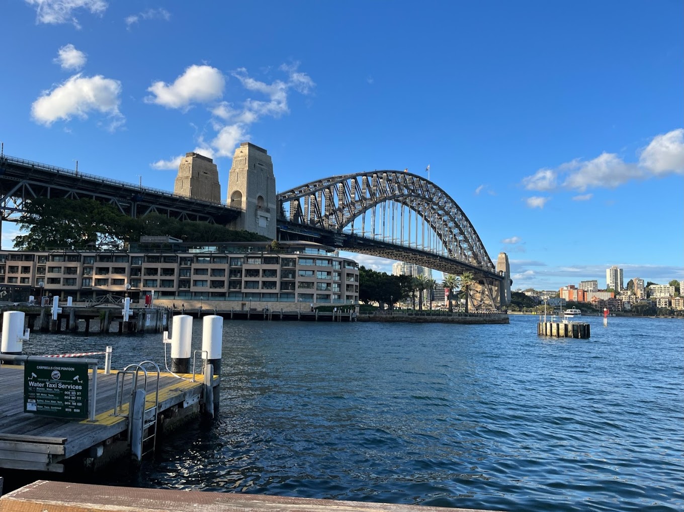View of the Sydney Harbour Bridge from Campbells Cove, with a water taxi dock in the foreground.
